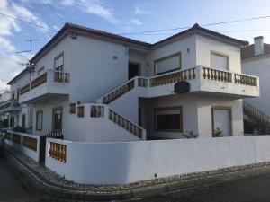 une maison blanche avec des balcons sur son côté dans l'établissement Refúgio do Almograve, à Almograve