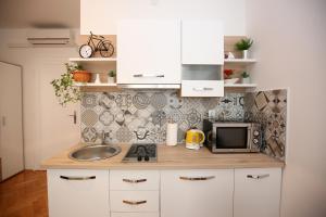 a small kitchen with a sink and a microwave at Apartment Noah in Zadar