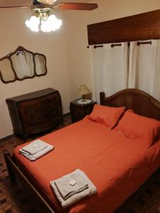 een slaapkamer met een bed met rode lakens en een spiegel bij Los Nogales de Yerua in Calabacillas
