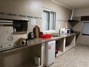 a kitchen with a counter with a sink and appliances at Los Nogales de Yerua in Calabacillas