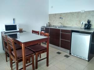 a kitchen with a table and chairs and a microwave at Sol Patagonia in Río Gallegos +25 photos