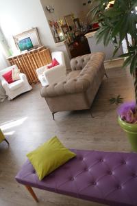 sala de estar con sofá y reposapiés púrpura en Hotel Tuscania Panoramico, en Tuscania