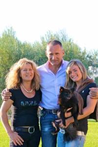 a man and two women standing with a dog at Agriturismo Le Rose in Pescia Romana