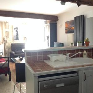 uma cozinha com um lavatório e uma sala de estar em Vieille Ville 1 - Luca's Apartment, 1 bedroom, max 2 adults and 2 kids em Antibes