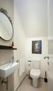 uma casa de banho com um WC, um lavatório e um espelho. em Liiiving in Porto | Downtown Terrace Apartment no Porto