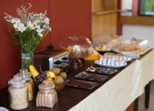 - un comptoir de cuisine avec une table, de la nourriture et des fleurs dans l'établissement Palace Hotel, à Nueve de Julio