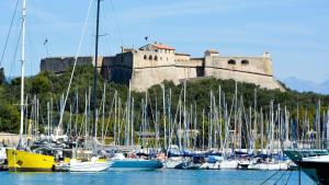 a bunch of boats docked in a harbor with a castle at Vieille Ville 1 - Luca's Apartment, 1 bedroom, max 2 adults and 2 kids in Antibes