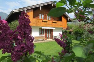 ein Haus mit einem Garten und lila Blumen in der Unterkunft Gästehaus Peter Wiedemann in Lenggries