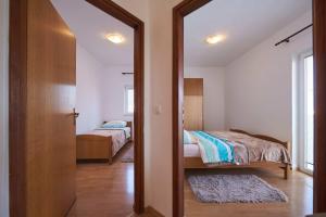a bedroom with two beds and a door with a mirror at Calypso in Kaštela