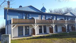 ein großes weißes Gebäude mit einem Balkon auf dem Dach in der Unterkunft Ferienwohnung Urte in Putgarten , Kap Arkona Rügen in Putgarten