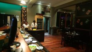 a restaurant with two people standing at a counter at Hotel Santa Mónica in Potosí