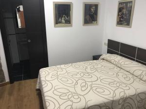 Un dormitorio con una cama y dos cuadros en la pared. en kilometro 15, en Amenal