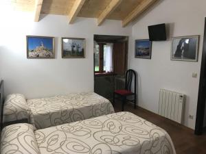 Una habitación de hotel con dos camas y un televisor. en kilometro 15, en Amenal