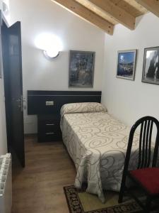 1 dormitorio pequeño con 1 cama y 1 silla en kilometro 15, en Amenal