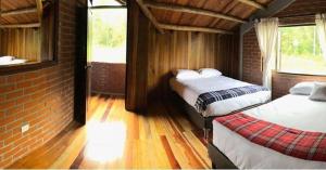 a bedroom with two beds and a brick wall at Chalet la Bonita in El Encano