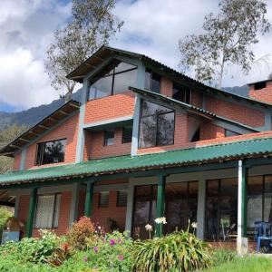 a red brick house with windows and flowers at Chalet la Bonita in El Encano