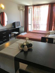 una camera d'albergo con due letti e un tavolo con un mobile da lavoro. di Sunny Apartment relax & spa a Burgas