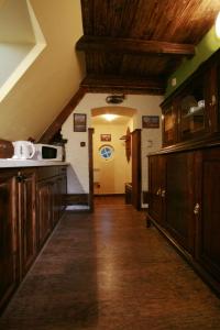 una cucina con armadi in legno e un lungo corridoio di Apartments Zámoček Staré časy a Poprad