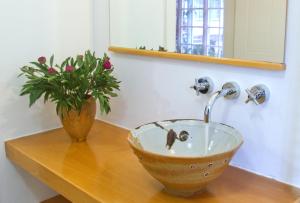 a bathroom sink with a faucet and a vase of flowers at Summerhill Guest Estate in Pinetown +20 photos