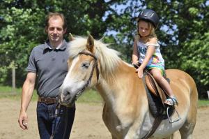 un hombre y una niña montando a caballo en Urlaub am Haberlehof, en Gurk