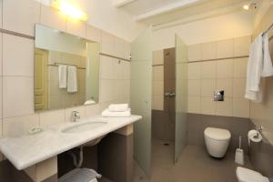 a bathroom with a sink and a toilet and a mirror at Carlo Bungalows in Agios Ioannis