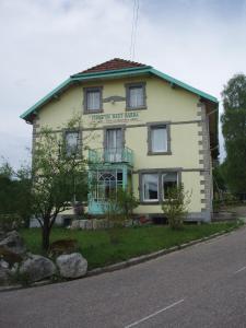 une grande maison blanche assise sur le côté d'une rue dans l'établissement FERME DU HAUT BARBA chambres d'hôtes & gîte, à Liézey