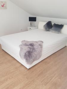 a white bed with two fuzzy pillows on it at The View in Viganj