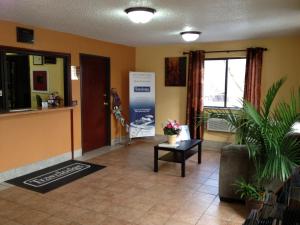 a lobby with a waiting room with a couch and a table at Travelodge by Wyndham Muskegon in Muskegon
