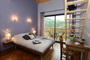 a bedroom with a bed with a view of a balcony at Lauz'oustal in Montrodat