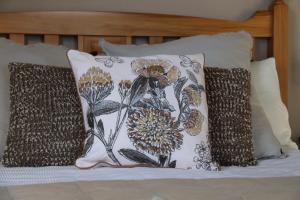 a pillow with a flower pattern on a bed at The Point B&B in Kaikoura