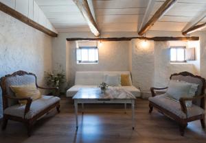 a room with a bed and two chairs and a table at La Casa de la Vieja - Rustic & Charming Appartments in Belmonte