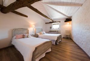 2 łóżka w pokoju z drewnianą podłogą w obiekcie La Casa de la Vieja - Alojamiento Rural 3 y 4 Estrellas w mieście Belmonte