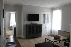 a living room with a flat screen tv on a wall at New One Bedroom Apartment Near Lake Winnipesaukee in Wolfeboro