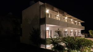 a building with lights on the side of it at night at Erato Hotel in Agia Marina Aegina