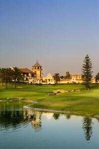 a golf course with a pond in front of a building at Los Arcos in Marbella