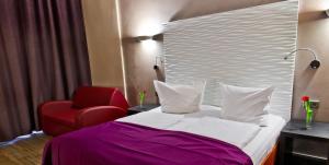 ein Hotelzimmer mit einem Bett und einem roten Stuhl in der Unterkunft Artim Hotel in Berlin + 27 Fotos