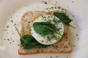 a egg on a piece of bread with greens on it at The Point B&B in Kaikoura