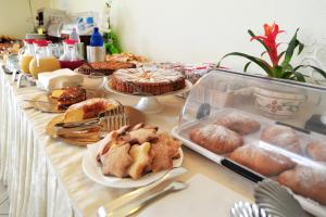 a long table with pastries and cakes on it at Hotel Stella Marina in San Teodoro