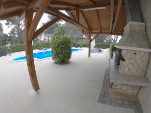 um pavilhão com uma lareira de pedra e uma piscina em Mam em Vir