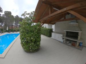 een patio met een zwembad en een paviljoen met een heg bij Mam in Vir