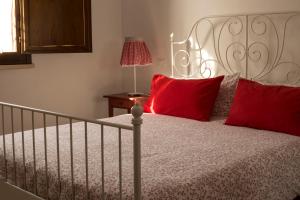 ボルゲリにあるAgriturismo Dallolivoのベッドルーム1室(赤い枕のベッド1台付)