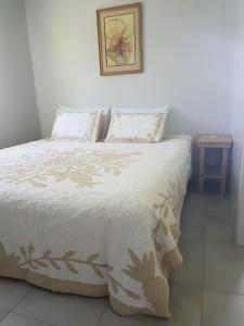 a bedroom with a white bed with two pillows at Sunset Quay in Rarotonga