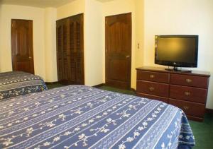 a hotel room with two beds and a flat screen tv at Apart-Hotel Posada San Judas in Guatemala