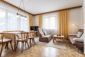 ein Wohnzimmer mit einem Tisch, Stühlen und einem Sofa in der Unterkunft Landhaus Kreuz in Schruns-Tschagguns