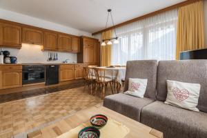 cocina y sala de estar con sofá y mesa en Landhaus Kreuz en Schruns