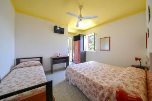 a bedroom with two beds and a ceiling fan at Hotel Piccolo Paradiso in Peschici