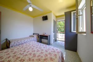 a bedroom with a bed and a window and a bed and a tv at Hotel Piccolo Paradiso in Peschici