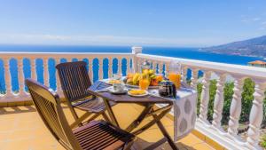 a table with fruit on a balcony with a view of the ocean at La Rivera Apartments in Tenagua