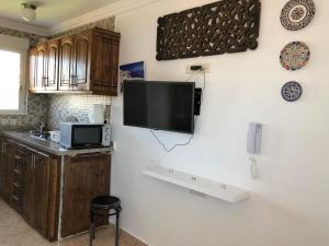 a kitchen with a flat screen tv on a wall at Residencial Lisboa in Ceuta