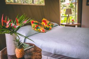 a bedroom with a bed with a pineapple on a table at Manoas in Uvita